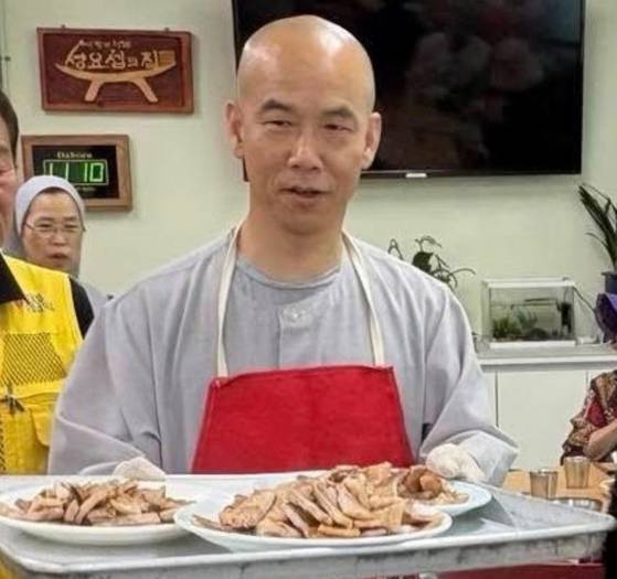 지난 12일 성요셉 사랑의 식당에서 문빈정사 법공스님이 구워진 고기를 나르고 있다. 사진 오영순 의원 페이스북 캡처