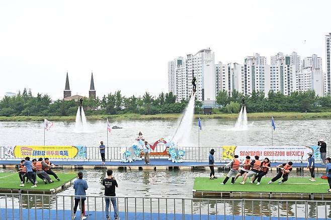 태화강변을 배경으로 한 수상 줄다리기에 참가한 시민들이 빗속에서도 뜨거운 열기를 발산하며 특별한 추억을 만들었다. 울산 중구 제공