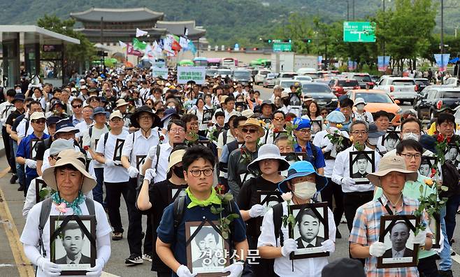 민족민주열사·희생자 유가족들이 15일 ‘제34회 민족민주열사·희생자 범국민 추모제’ 시작에 앞서 서울 광화문에서 영정사진을 가슴에 안고 거리행진을 하고 있다. 서성일 선임기자