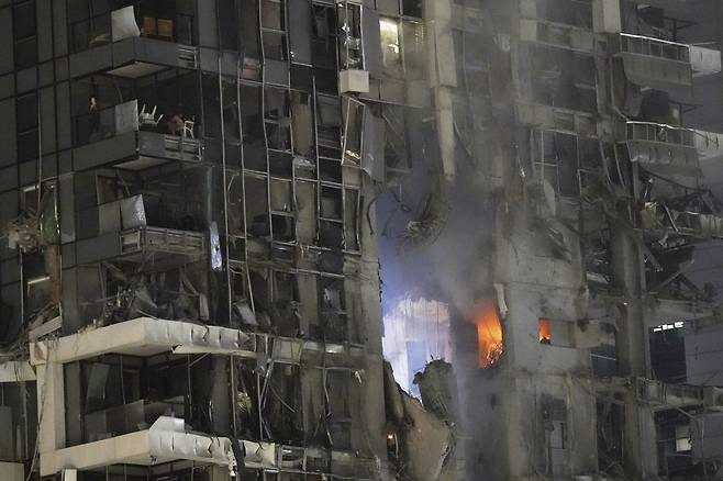 Fire and smoke rises from a destroyed building that was hit by a missile fired from Iran, in Tel Aviv, Israel on June 13. [AP/YONHAP]