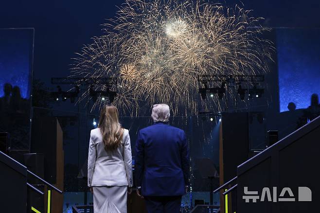 [워싱턴=AP/뉴시스]도널드 트럼프 미국 대통령이 부인인 멜라니아 여사와 함께 14일(현지 시간) 미국 워싱턴DC에서 열린 미 육군 250주년 군사 퍼레이드 말미 불꽃놀이를 지켜보고 있다. 2025.06.15.