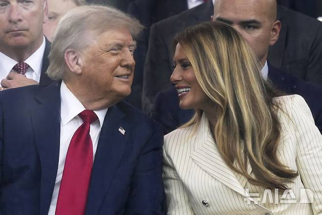 [워싱턴=AP/뉴시스]도널드 트럼프 미국 대통령이 부인인 멜라니아 여사와 14일(현지 시간) 미국 워싱턴DC에서 열린 미 육군 250주년 군사 퍼레이드를 지켜보며 미소짓고 있다. 2025.06.15.