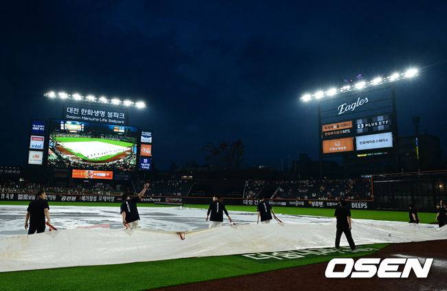 [OSEN=대전, 지형준 기자] 15일 대전 한화생명볼파크에서 2025 신한 SOL Bank KBO리그 한화 이글스와 LG 트윈스의 경기가 열렸다.이날 한화는 문동주, LG는 송승기를 선발로 내세웠다.5회말 경기가 중단된 가운데 비가 잦아들며 방수포를 걷고 경기 재개를 준비하고 있다. 2025.06.15 /jpnews@osen.co.kr