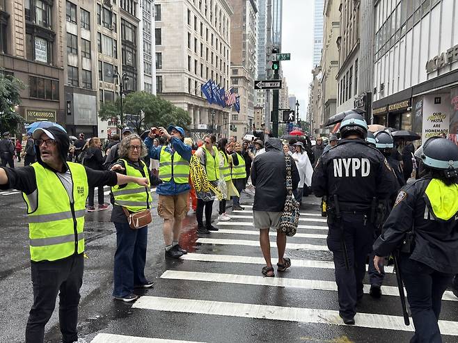 '노 킹스' 집회 현장의 자원봉사 안전요원 (뉴욕=연합뉴스) 이지헌 특파원 = 14일(현지시간) 미국 뉴욕 맨해튼 거리에서 열린 '노 킹스' 집회 현장에서 자원봉사 안전요원들이 시위대 안전을 위해 길을 막고 있다. 2025.6.14 pan@yna.co.kr
