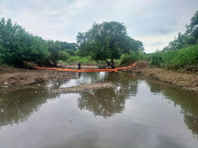 광주공장 화재 직후 "하천 오염은 없다"고 단언한 광산구는 현재 화재 잔류물이 황룡강 지류로 유입된 정황이 드러나면서 제대로 관리감독을 못한 비난을 피할 수 없게 됐다. 사진은 황룡강 지류 하천에 설치된 오일펜스를 따라 관계자들이 오염 확산 방지 작업을 진행하는 모습. /광산구 제공