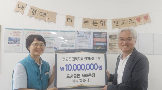 서해문집 김흥식 대표(오른쪽)가 창립 36주년을 맞은 전국교직원노동조합 전북지부 오도영 지부장에게 장학금을 전달하고 있다./전교조 전북지부 제공