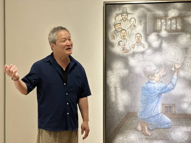 지난 13일 부산 민주공원 광복 80돌 맞이 기념 전시 '독립하는 광복'에 참석한 노주일 작가가 작품 '감옥에서 꿈'에 대해 설명하고 있다. 김은영 기자