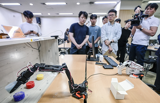 대구 영남일보 사옥(영남타워) 대강당에서 14~16일 열린 '허깅페이스 르로봇 해커톤' 한국대회에서 심사위원들이 경북대 Knubotis팀이 프로그래밍 한 로봇팔이 양초를 분별 수거하는 작업을 수행하는 모습을 관찰하고 있다. 이현덕기자 lhd@yeongnam.com