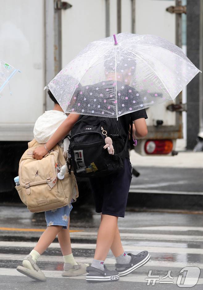 장맛비가 내리는 지난 13일 전북 완주군 한 초등학교 인근 횡단보도에서 우산을 쓴 어린이들이 발걸음을 재촉하고 있다. 2025.6.13/뉴스1 ⓒ News1 유경석 기자