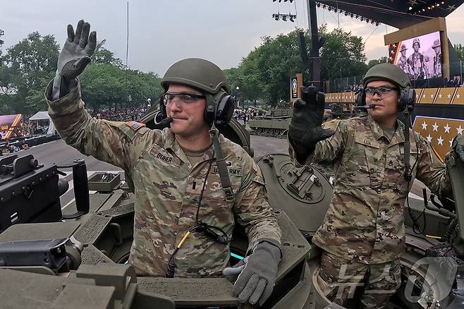전차를 탄 군인들이 시민에게 손을 흔들고 있다. ⓒ 로이터=뉴스1 ⓒ News1 박형기 기자