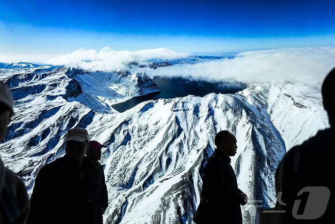 11일(현지시간) 백두산 북파지역을 찾은 관광객들이 백두산 천지 광고판 앞을 지나고 있다. (공동취재) 2025.6.16/뉴스1 ⓒ News1 황기선 기자