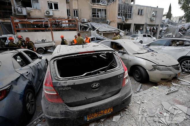 16일(현지시간) 이란의 미사일 발사로 이스라엘 텔아비브의 건물들과 차량들이 큰 피해를 입은 가운데 소방 대원들이 비상 대응을 하고 있다. 2025.06.16 ⓒ AFP=뉴스1 ⓒ News1 최종일 선임기자