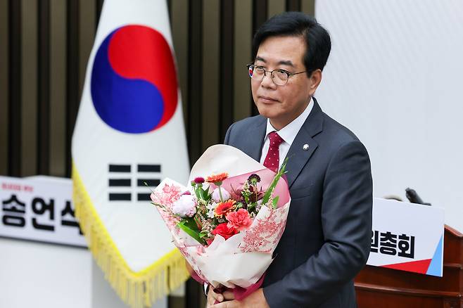 국민의힘 신임 원내대표로 선출된 송언석 의원이 16일 오후 서울 여의도 국회에서 열린 의원총회에서 꽃다발을 들고 있다. /뉴스1