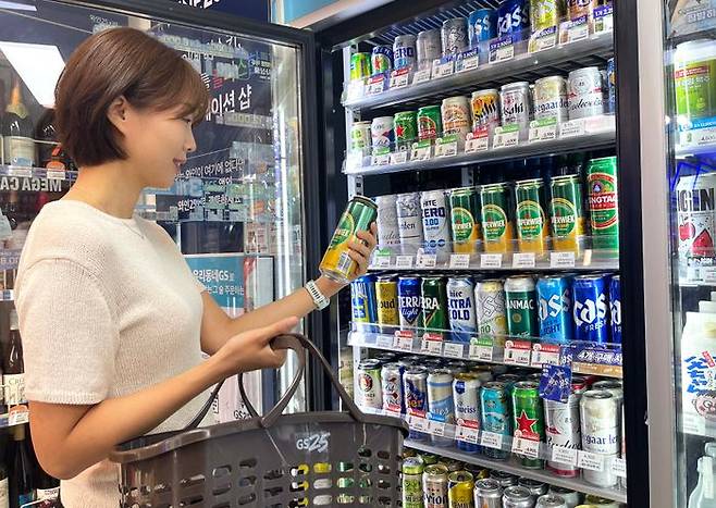 고객이 GS25에서 5캔 5000원 행사로 1캔당 1000원에 구매할 수 있는 ‘코퍼웍캔 500ml’ 발포주를 살펴보고 있다.ⓒGS25