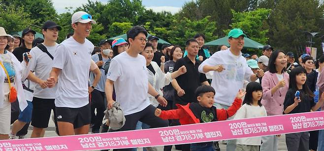 14일 서울 남산 일원에서 열린 ‘손목닥터9988 남산 걷기&기부 챌린지’에서 오세훈 서울시장(오른쪽 녹색 모자)과 시민들이 준비운동을 하고 있다. 서울시는 손목닥터 이용자 200만 돌파를 기념해 챌린지 완주자에게 손목닥터9988 포인트 1000점을 지급했다. 서울시 제공