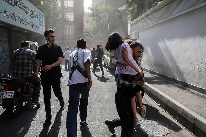 15일 이스라엘군의 공습 뒤 거리로 나온 시민들이 뛰고 있다. WANA 연합뉴스