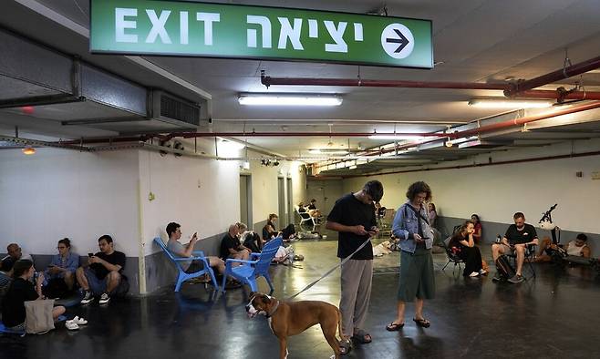 15일, 이스라엘 텔아비브에서 미사일 공습 경보 사이렌이 울린 뒤 시민들이 대피해 있다. AP연합뉴스