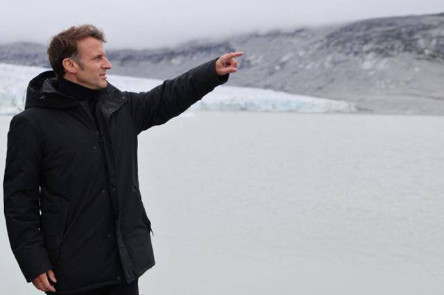 에마뉘엘 마크롱 프랑스 대통령이 15일 덴마크 자치령인 그린란드 북서부에 위치한 누나타르수아크 산 정상에 서서 손짓을 하고 있다. 이날 방문은 주요7개국(G7) 정상회의 참석을 위해 캐나다로 향하는 길목에 이뤄졌다. 누나타르수아크=AFP 연합뉴스