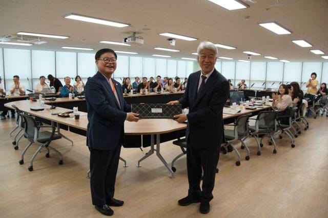 김문훈(오른쪽) 포도원교회 목사가 교회를 방문한 대만 목회자들을 대표해 장한업 타이베이순복음교회 목사에게 선물을 전달하는 모습.