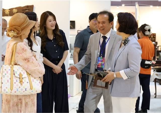 김경수(오른쪽 두 번째) 한국고미술협회장이 작년 6월 ‘2024 한국고미술아트페어’에서 개그우먼 김승혜(〃 세 번째) 씨 등 참석자들과 대화를 나누고 있다.  고미술협회 제공