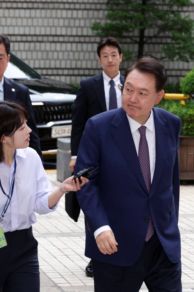 윤석열 전 대통령이 16일 서울 서초구 서울중앙지방법원에서 열린 내란 우두머리 혐의·직권남용 권리행사 방해 혐의 사건 7차 공판에 출석하며 지지자들을 바라보고 있다.  연합뉴스