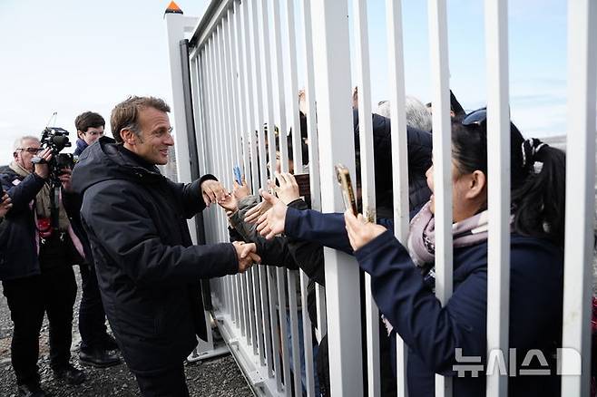 [누크=AP/뉴시스] 에마뉘엘 마크롱(왼쪽) 프랑스 대통령이 15일(현지시간) 그린란드 누크 공항에서 현지 주민들과 인사를 나누고 있다. 마크롱 대통령은 덴마크 자치령 그린란드를 찾아 "그린란드는 매물도 아니고 강제로 뺏을 수 곳도 아니다"라고 밝혔다. 2025.06.16.