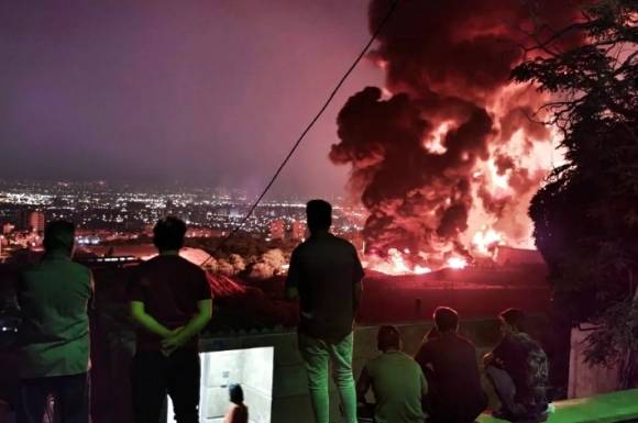 이란 국민들이 이스라엘 공격으로 불길에 휩싸인 석유 저장고의 모습을 바라보고 있다. 게티이미지 / 멀티비츠