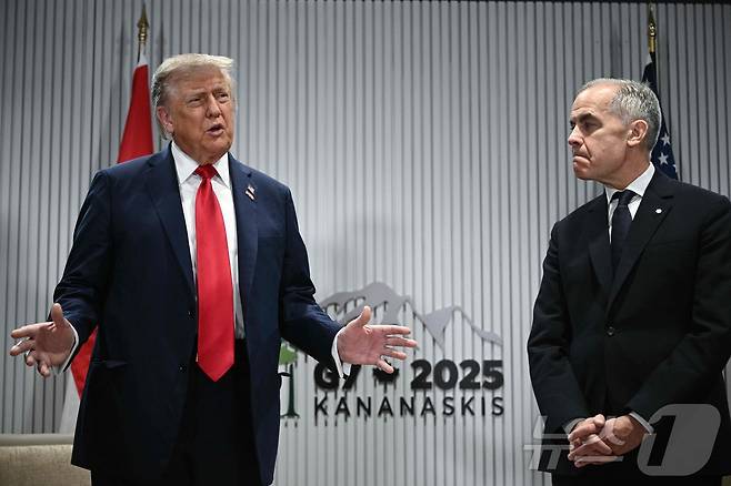 도널드 트럼프 미국 대통령이 16일(현지시간) 캐나다 앨버타주 캐내내스키스에서 열린 주요 7개국(G7) 정상회의에서 마크 카니 캐나다 총리가 지켜보는 가운데 기자 질문에 답하고 있다. 트럼프 대통령은 "G7이 과거 G8이었던 시절을 기대한다＂면서 2014년 러시아의 크림반도 강제 병합을 문제 삼아 러시아를 퇴출한 결정은 실수였다고 주장했다. 2025.06.16 ⓒ AFP=뉴스1 ⓒ News1 류정민 특파원