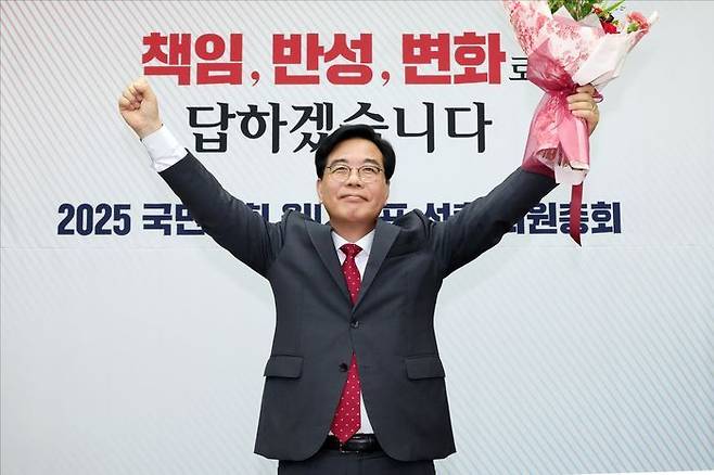송언석 국민의힘 신임 원내대표가 16일 오후 국회에서 열린 2025 국민의힘 원내대표 선출 의원총회에서 꽃다발을 든 채 손을 들어올리고 있다. ⓒ데일리안 홍금표 기자