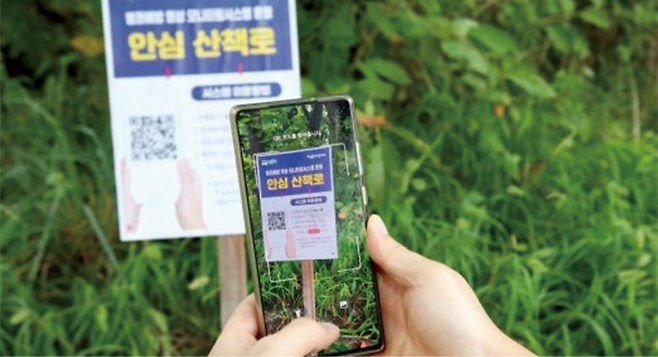 스마트폰으로 QR 코드를 스캔해 ‘산책로 범죄예방시스템’을 이용하는 모습. 성동구 제공