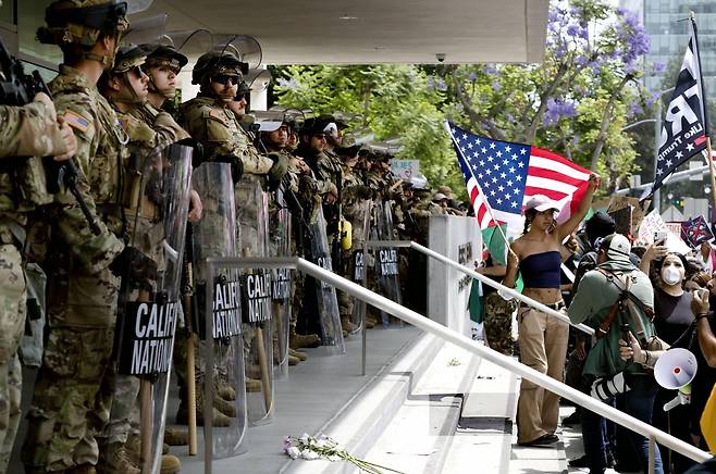 14일 캘리포니아주 로스앤젤레스 시내의 한 연방정부 건물 앞에서 ‘노 킹스’ 시위가 열렸다. 건물 입구를 봉쇄한 주방위군 앞에서 시위하는 시민들. 로스앤젤레스=AP 뉴시스