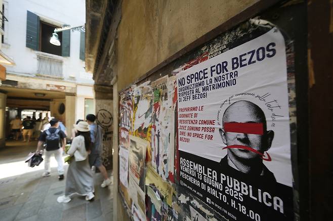 지난 12일(현지시간) 이탈리아 베니스의 한 벽에 ‘제프 베조스 결혼식 반대’ 시위 포스터가 붙어 있다. AP=연합뉴스