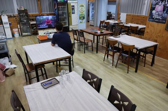 지난 5일 경남 거제시 장평동 재래시장 한 횟집에서 사장이 TV를 보며 손님을 기다리고 있다. 송봉근 기자