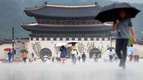 서울 지역에 소나기가 내린 16일 서울 광화문광장에서 우산을 쓴 관광객 및 시민이 길을 지나고 있다. 연합뉴스
