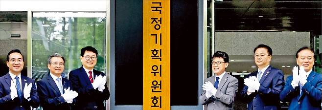 < 서울청사서 현판식 > 이재명 정부 대통령직인수위원회 역할을 할 국정기획위원회가 출범한 16일 정부서울청사 창성동 별관에서 참석자들이 현판식을 하고 있다. 왼쪽부터 박홍근 더불어민주당 의원, 김용범 대통령실 정책실장, 이한주 국정기획위원장, 진성준 민주당 정책위원회 의장, 방기선 국무조정실장, 정태호 민주당 의원. 김범준 기자