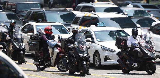 이재명 대통령의 공정경제 실현을 위한 공약이었던 '배달플랫폼 수수료 상한제' 도입에 대한 관심이 커지고 있는 가운데 서울 강남역 사거리에서 배달라이더들이 교통신호를 기다리고 있다. 사진=연합뉴스