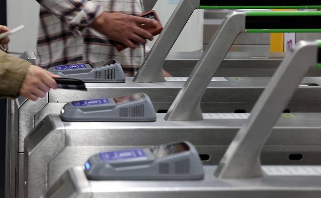 Passengers tap their cards at ticket barriers in a subway station in Seoul. [NEWS1]