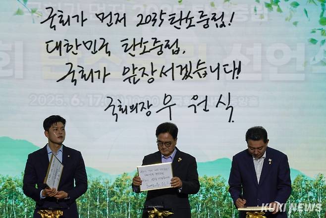 우원식 국회의장과 김병기 더불어민주당 당대표 직무대행 겸 원내대표, 김용태 국민의힘 비상대책위원장 등이 17일 서울 여의도 국회 로텐더홀에서 열린 '국회 탄소중립 선언식'에서 탄소중립을 약속하는 서약서에 서명한 뒤 기념사진을 촬영하고 있다.