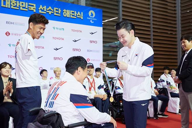 < 배동현 선수단장이 지난 ‘2024 파리 패럴림픽 대회’ 해단식에서 사격 장성원 감독에게 순금 메달을 수여했다 / BDH재단 제공 >