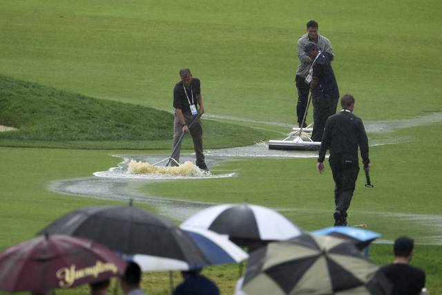 페어웨이인가 해저드인가 : 미국 펜실베이니아주 오크몬트 컨트리클럽 관계자들이 16일(한국시간) 갑작스러운 많은 비에 남자골프 메이저대회 US오픈 4라운드가 잠시 중단된 사이 페어웨이에 고인 물을 쓸어내고 있다. AP 연합뉴스