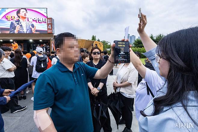 6월2일 대구 수성구 수성못 인근에서 열린 이준석 후보 마지막 유세에서 이준석 후보 지지자가 3차 TV 토론 발언을 그대로 옮긴 영상을, 해당 발언에 항의하는 시민 앞에서 재생하고 있다. ⓒ시사IN 박미소