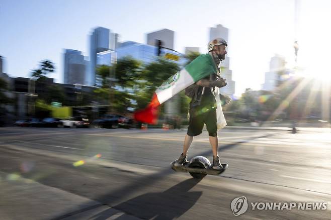지난 15일 LA에서 전동 스쿠터 타고 지나가는 시위대  [AP=연합뉴스. 재판매 및 DB 금지]