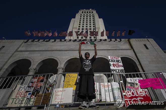 지난 15일 LA 도심에서 멕시코 국기를 들고 있는 시위자 [AP=연합뉴스. 재판매 및 DB 금지]
