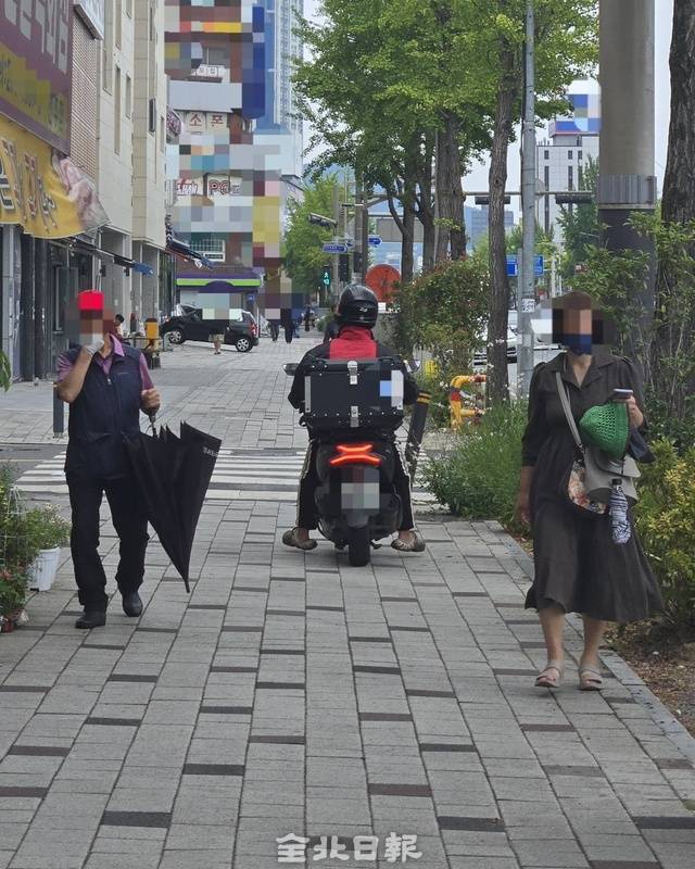 전주시 완산구의 한 보행로를 오토바이가 주행하고 있다. 김경수 기자