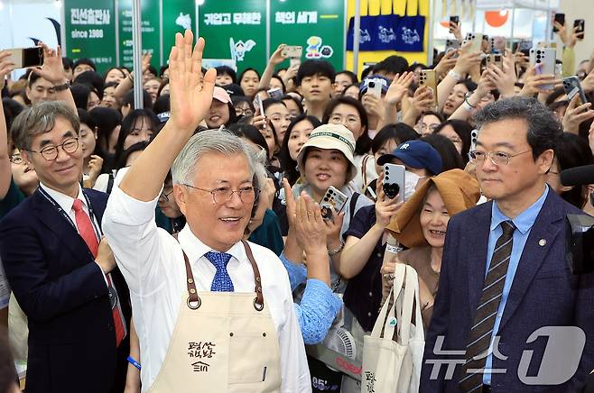 문재인 전 대통령이 18일 오후 서울 강남구 삼성동 코엑스에서 열린 2025 서울국제도서전 평산책방 부스에서 앞치마를 두르고 나와 방문객들에게 인사하고 있다. 2025.6.18/뉴스1 ⓒ News1 박정호 기자