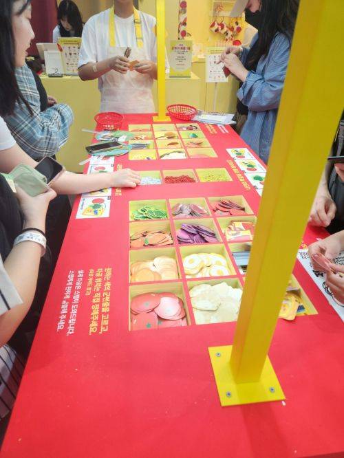다산북스가 오뚜기와 협업해 선보인 이벤트 코너, 관람객들이 각종 음식 재료 이미지를 엮어 자신만의 책갈피 키링을 만들고 있다.