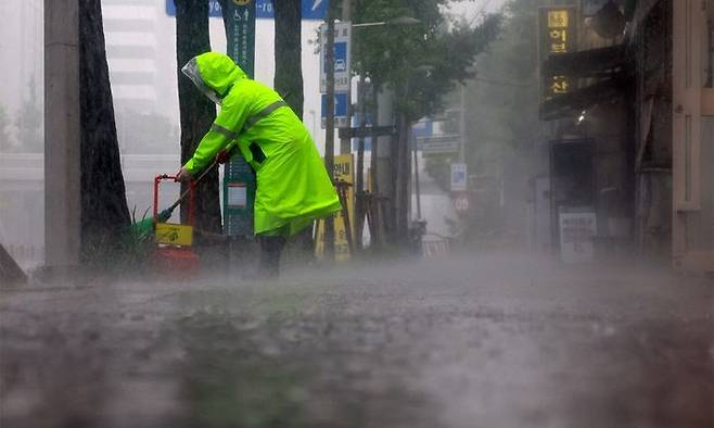 지난 16일 폭우가 쏟아진 서울 서대문구에서 환경미화원이 인도를 청소하고 있다.ⓒ연합뉴스