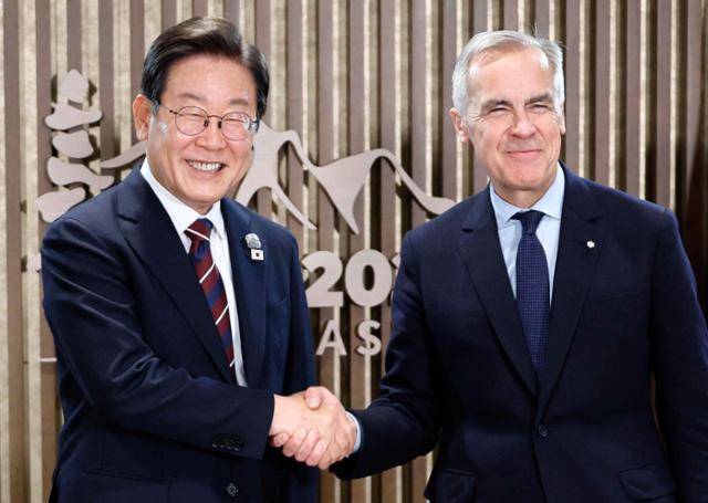 이재명 대통령이 17일(현지시간) 캐나다 앨버타주 캐내내스키스 주요 7개국(G7) 정상회의장에서 열린 한-캐나다 정상회담에서 마크 카니 캐나다 총리와 악수하며 기념촬영을 하고 있다. 캐내내스키스=연합뉴스