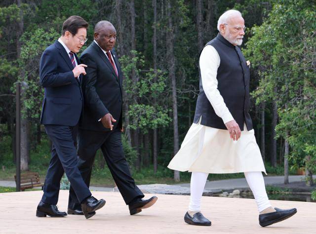 이재명 대통령과 시릴 라마포사 남아프리카공화국 대통령이 17일(현지시간) 캐나다 앨버타주 캐내내스키스 주요 7개국(G7) 정상회의장에서 G7 및 초청국 기념촬영을 위해 이동하며 대화하고 있다. 앞쪽은 나렌드라 모디 인도 총리. 캐내내스키스=연합뉴스