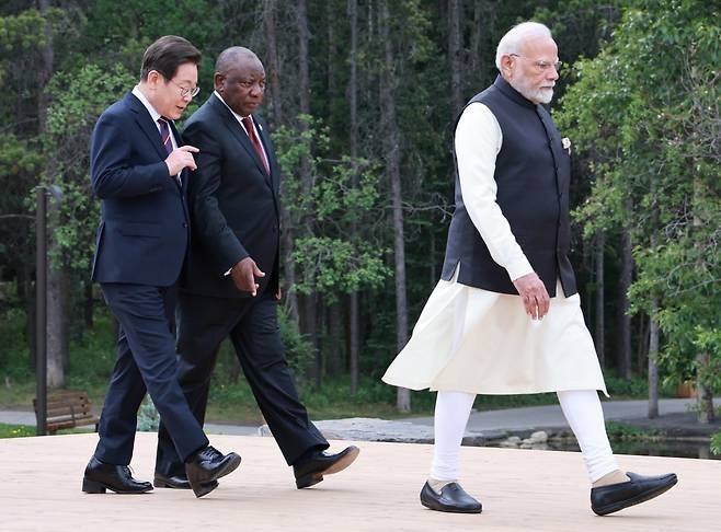 이재명 대통령이 17일(현지시간) 주요 7개국(G7) 정상회의가 열리고 있는 캐나다 캐내내스키스에서 단체 기념사진 촬영을 위해 걸어가며 시릴 라마포사 남아프리카공화국 대통령과 대화를 하고 있다. 앞에는 나렌드라 모디 인도 총리. 대통령실사진기자단